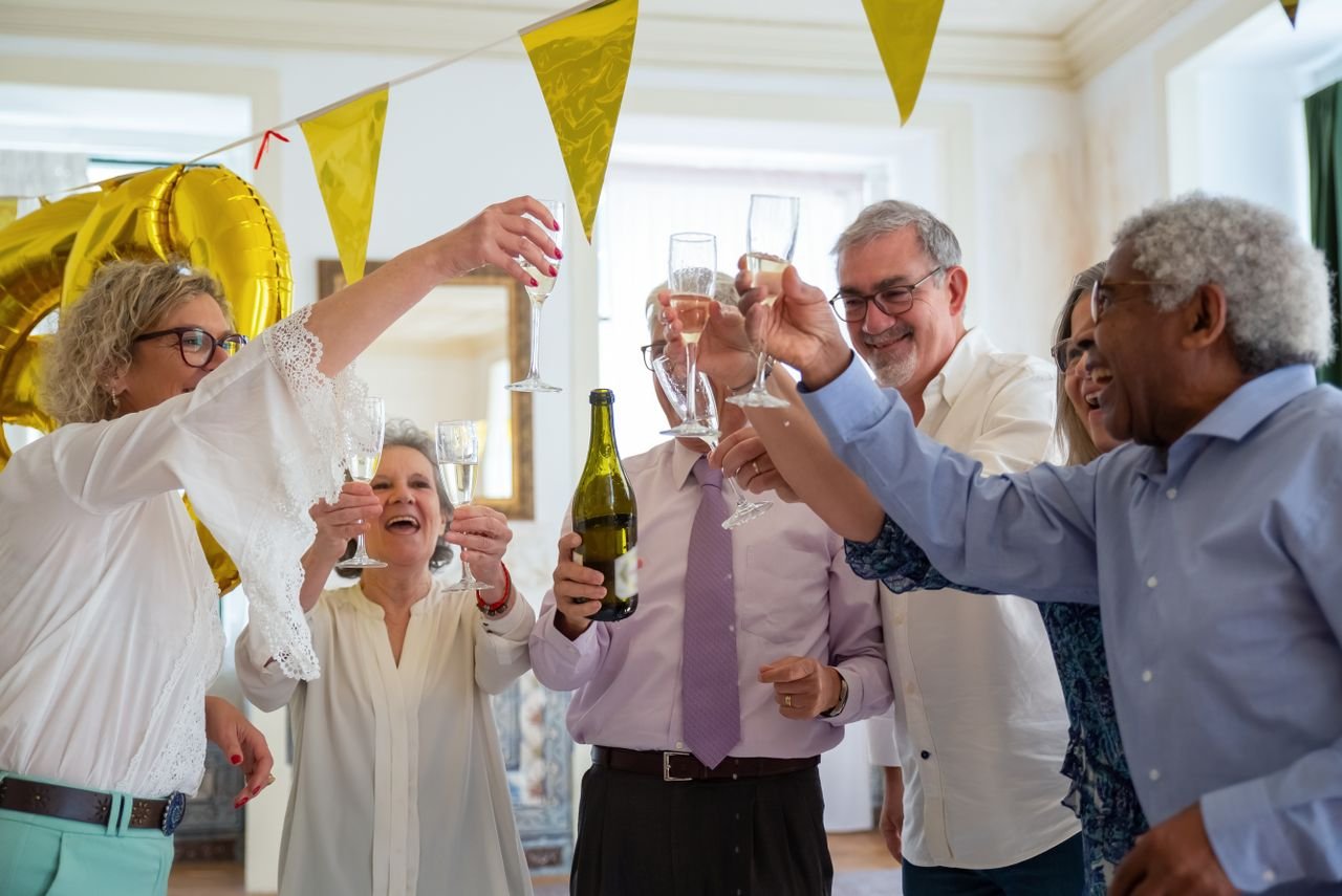 services-01 A group of diverse friends joyfully toasting with champagne at an indoor celebration.