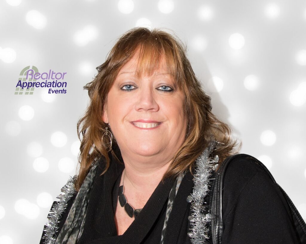 Guest posing in front of the Realtor Appreciation Events photo booth backdrop